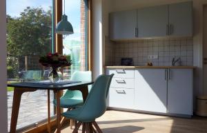 una cucina con tavolo, sedie e finestra di Frida - Feines Studio mit Südterrasse a Steinkirchen