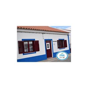 ein kleines weißes Haus mit roten Akzenten in der Unterkunft Casa do Avô Tó in Reguengos de Monsaraz