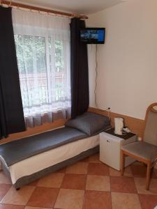 a small bed in a room with a window at Obłoczek in Łeba