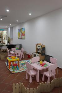 a room with tables and chairs and a play area at Heeren Straits Hotel in Malacca