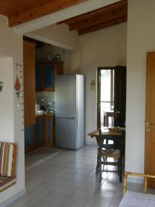 a kitchen with a refrigerator and a table at Orfeas -Vacation Home in Paralia Panteleimonos
