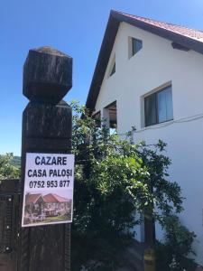 a sign on a pole in front of a house at Conacul Paloși in Horezu