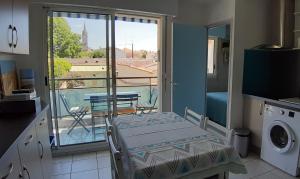 een keuken met een bed en uitzicht op een balkon bij Appartement 2 min à pied de la mer et du centre ville in Saint-Georges-de-Didonne