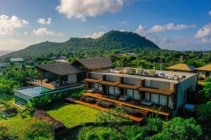an aerial view of a house with a mountain in the background at Colina Pousada SPA in Fernando de Noronha