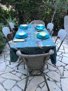 a table with a blue table cloth on a patio at "L'olivadou" ST JEAN CAP FERRAT in Saint-Jean-Cap-Ferrat