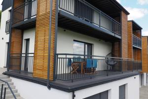un balcone con tavolo e sedie su un edificio di RelaxApart - Komfortowy apartament z prywatną sauną a Szczyrk