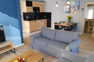 un soggiorno con divano e tavolo di RelaxApart - Komfortowy apartament z prywatną sauną a Szczyrk
