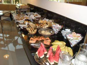 uma linha de buffet com muitos tipos diferentes de alimentos em Hotel Master em Governador Valadares