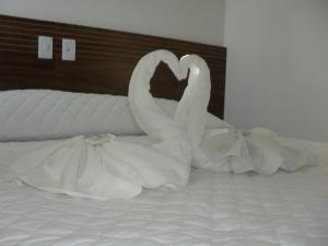 dos cisnes blancos están sentados en una cama en Hotel Master, en Governador Valadares