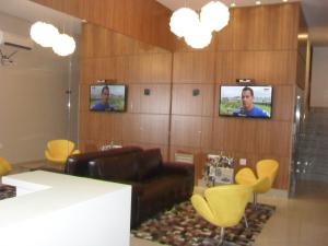 uma sala de estar com um sofá e duas televisões em Hotel Master em Governador Valadares