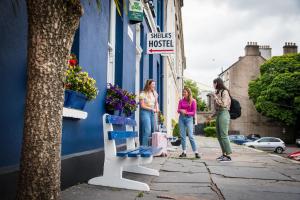 Tre donne sono in piedi fuori da un edificio di Sheilas Tourist Hostel a Cork