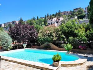 a swimming pool in a garden with trees and buildings at Villamena in Spello
