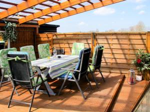 a patio with a table and chairs on a deck at Apartment Osterende-1 by Interhome in Süderwisch