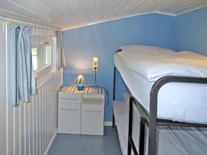 a small room with a bunk bed and a night stand at Apartment Osterende-1 by Interhome in Süderwisch