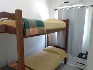 two bunk beds in a room with a window at Cantinho Da Del in Recife