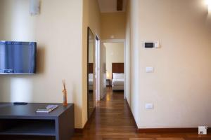 einen Flur eines Hotelzimmers mit einem TV an der Wand in der Unterkunft Appartamenti Resort Roma 6.3 e Resort I Banchieri in Ravenna