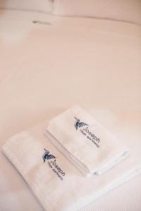 two white towels sitting on top of a bed at Joseph Village Apartments in Fourka +57 photos
