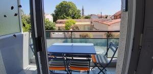 een tafel en stoelen op een balkon met uitzicht bij Appartement 2 min à pied de la mer et du centre ville in Saint-Georges-de-Didonne