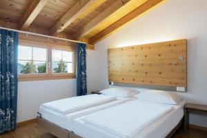 two twin beds in a room with a window at Hapimag Ferienwohnungen Flims in Flims
