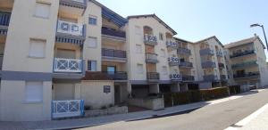 een rij appartementen met blauwe balkons bij Appartement 2 min à pied de la mer et du centre ville in Saint-Georges-de-Didonne