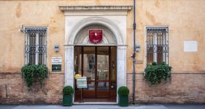 une porte menant à un bâtiment avec un panneau sur celui-ci dans l'établissement Appartamenti Resort Roma 6.3 e Resort I Banchieri, à Ravenne