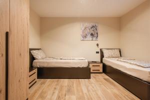 1 dormitorio con 2 camas y suelo de madera en CASA MARTINELLI en Tremosine Sul Garda