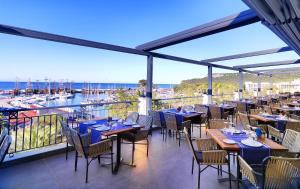 a restaurant with tables and chairs on a balcony at Imperial Türkiz Resort Hotel & SPA in Kemer