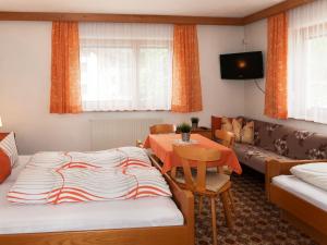 1 dormitorio con cama, mesa y sofá en Apartment Garni Regina - KPL642 by Interhome, en Kappl