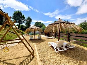 eine Gruppe von Stühlen und Sonnenschirmen am Strand in der Unterkunft Domaradzkie Wzgórze in Domaradz