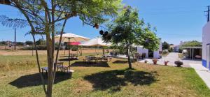 a garden with tables and chairs and an umbrella at Retiro dos Batudes in Palmela