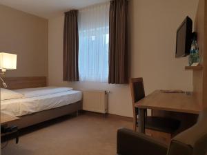 a hotel room with a bed and a table and a window at Hotel Wetzlarer Hof in Wetzlar