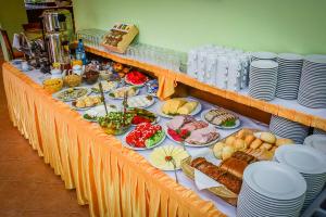 a long table with food on it with plates at Villa Sylvia in Dźwirzyno