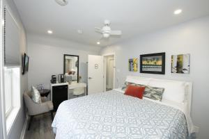a bedroom with a white bed and a desk and a chair at Serene Niagara Inn in Niagara Falls