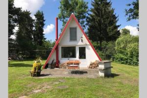 una pequeña casa con techo rojo en un campo en Matilda II - lovely Matilda, en Wesenberg