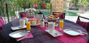 una mesa con un mantel púrpura con comida. en Villa Solary, en Le Pontet
