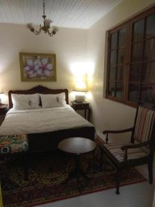 a bedroom with a bed and a chair and a table at Hostel Pousada Rheingantz Rio Grande in Rio Grande