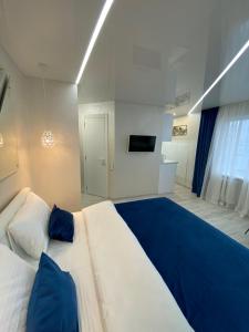 una camera da letto con un grande letto con una coperta blu di New Studio in the center of Kiev a Kiev