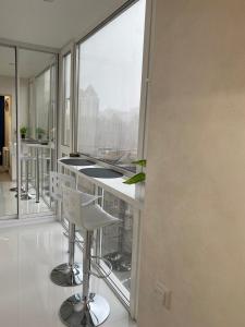 una cucina con bar con sgabelli e ampia finestra di New Studio in the center of Kiev a Kiev
