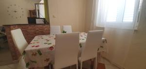 a dining room table and chairs with a floral table cloth at Apartments New Charming in Senj