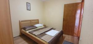 a bedroom with a bed and a wooden door at Apartments New Charming in Senj