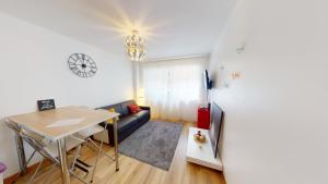 a living room with a couch and a table and a refrigerator at Aux bons amis - Parlement/Orangerie in Strasbourg +5 photos