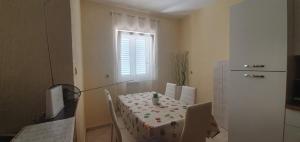 a room with a table and a kitchen with a window at Apartments New Charming in Senj