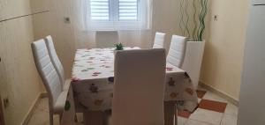 a dining room table and chairs with a table and a tablecloth at Apartments New Charming in Senj