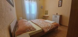 a small bedroom with a bed with a window at Apartments New Charming in Senj