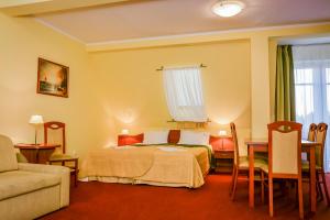 pokój hotelowy z łóżkiem, stołem i krzesłami w obiekcie Villa Sylvia w Dźwirzynie
