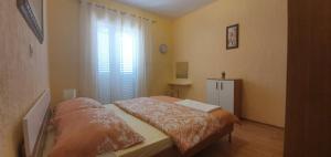a small bedroom with a bed and a window at Apartments New Charming in Senj