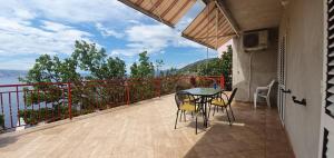 a patio with a table and chairs on a balcony at Apartments New Charming in Senj