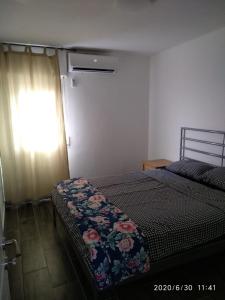 ein Schlafzimmer mit einem Bett und einem Fenster mit einem Vorhang in der Unterkunft Lake Resort in Tiberias