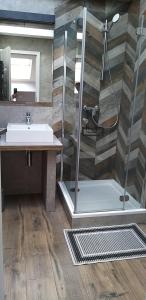 łazienka z prysznicem i umywalką w obiekcie Apartamenty Rynek we Wrześni +5 zdjęć