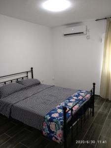 un letto in una camera bianca con struttura nera di Lake Resort a Tiberias